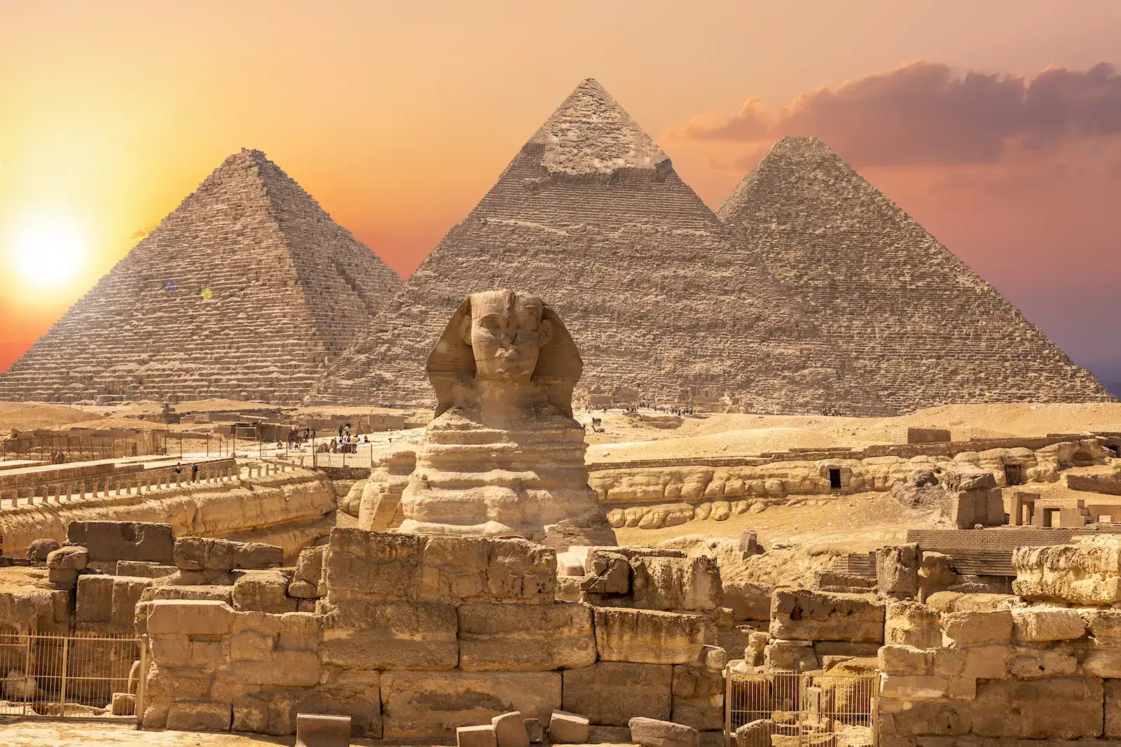 The Great Sphinx and the pyramids of Giza glowing at sunset near Cairo, Egypt