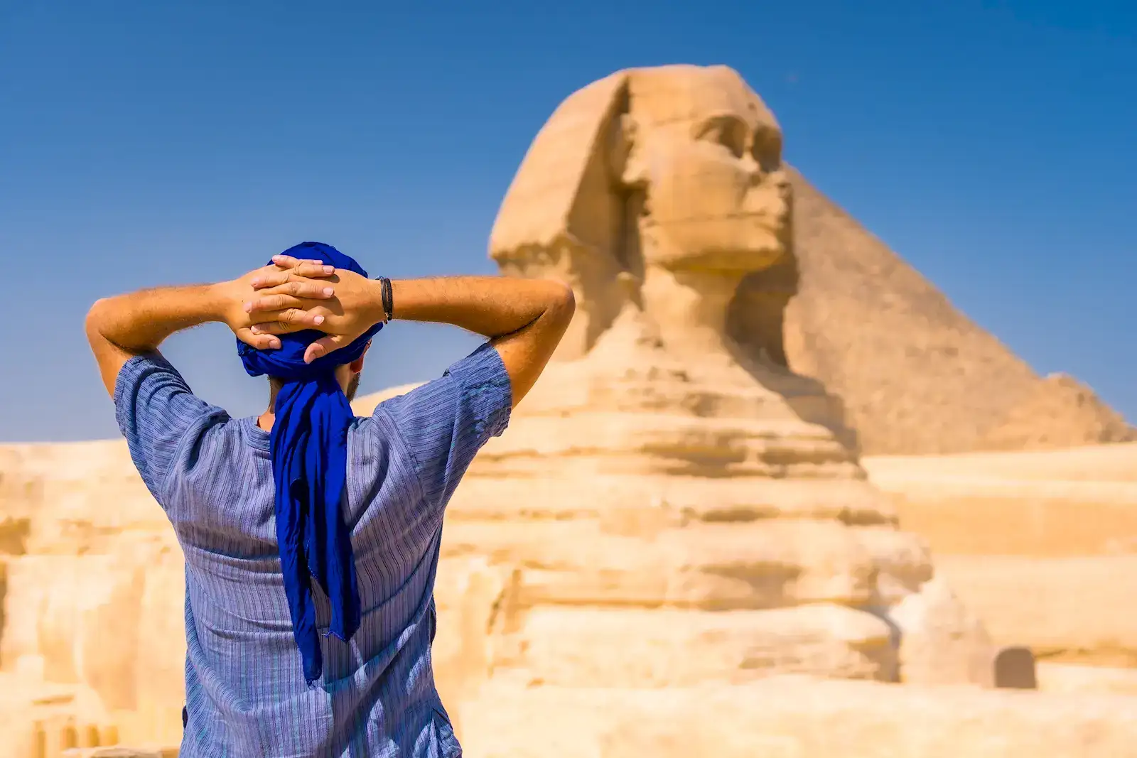 A traveller looking up at the Great Sphinx of Giza